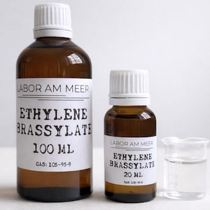 May include: Two brown glass bottles with white caps and labels that read "ETHYLENE BRASSYLATE" and "LABOR AM MEER". One bottle is 100 ml, the other is 20 ml. A small beaker with a clear liquid is also present.
