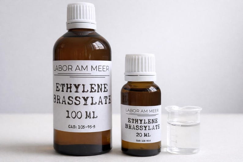 May include: Two brown glass bottles with white caps and labels that read "ETHYLENE BRASSYLATE" and "LABOR AM MEER". One bottle is 100 ml, the other is 20 ml. A small beaker with a clear liquid is also present.