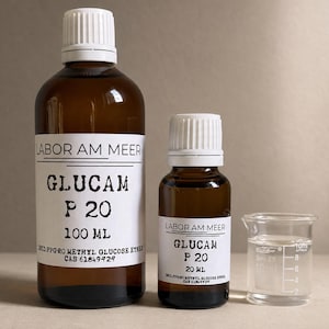 May include: Two amber glass bottles with white caps and white labels reading Labor Am Meer Glucam P 20. One bottle is 100 ml and the other is 20 ml. Next to them is a small clear glass beaker with 10 ml markings containing a clear liquid.