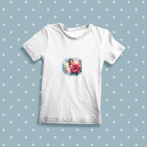 Op de afbeelding: Wit T-shirt met een kleurrijk beeld van een fee met een bloemenkroon en een kerstster.