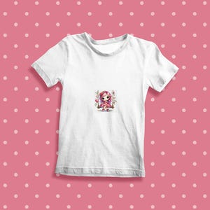 May include: White t-shirt with a pink and white cartoon girl on a swing with flowers.