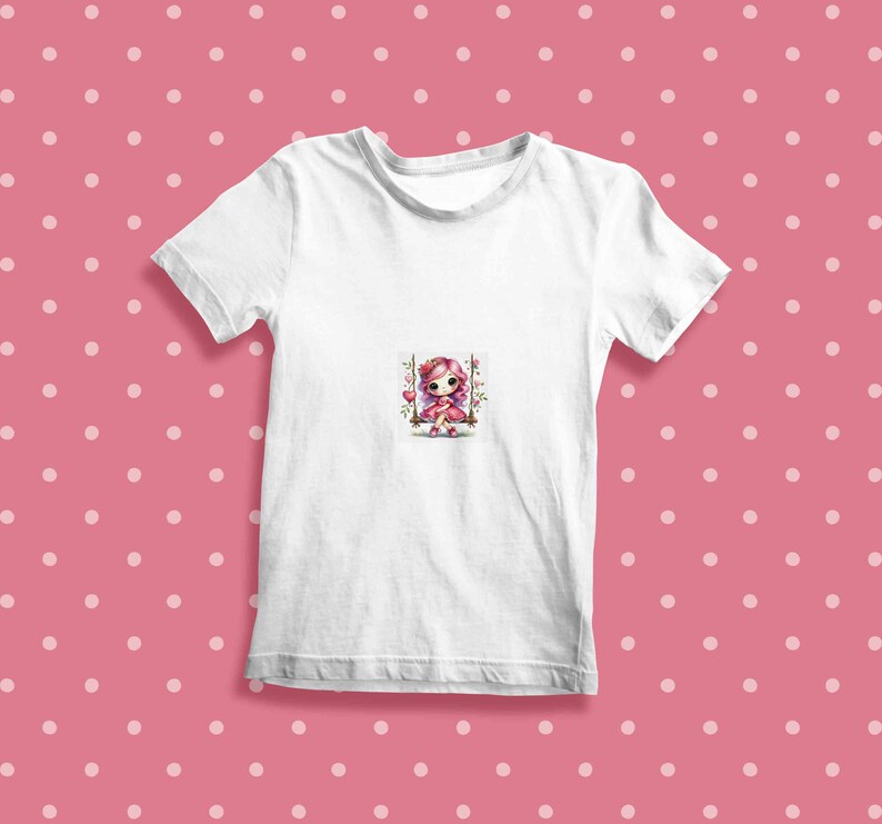 May include: White t-shirt with a pink and white cartoon girl on a swing with flowers.