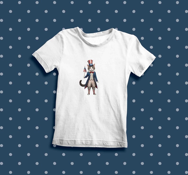 May include: White t-shirt with a cartoon illustration of a cat wearing a red, white, and blue Uncle Sam hat and holding a small American flag.