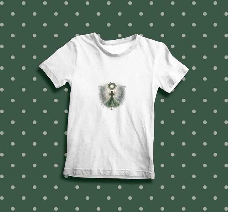 May include: White t-shirt with a green fairy illustration wearing a crown and holding a glowing orb. The fairy has wings and is surrounded by a halo of light.