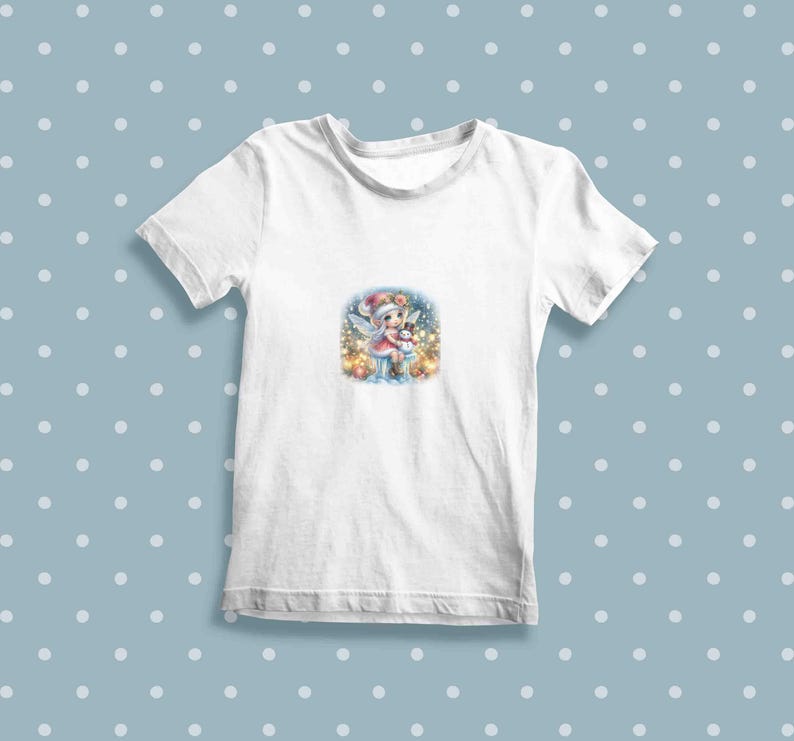 May include: White t-shirt with a colorful illustration of a fairy holding a snowman in a winter scene.