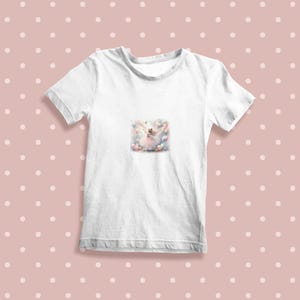 K&ouml;nnte beinhalten: Wei&szlig;es T-Shirt mit einem bunten Motiv einer Ballerina, die von Ballons umgeben ist.