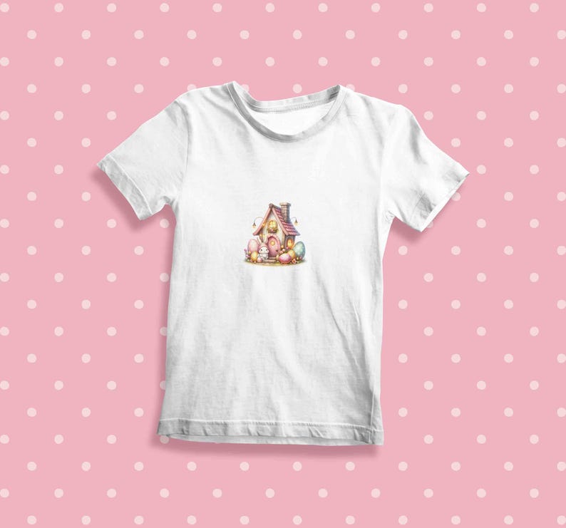 May include: White t-shirt with a colorful illustration of a small house with a birdhouse on top.  The house is surrounded by colorful eggs and small chicks.