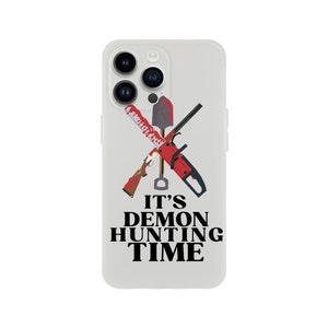 May include: White iPhone case featuring a graphic of a chainsaw, shovel, and shotgun crossed over each other. The text "IT'S DEMON HUNTING TIME" is displayed below the graphic.