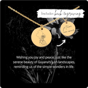 May include: Gold necklace with a round pendant featuring a detailed outline of Guyana and a water lily. The back of the pendant is engraved with the text "je taime mon amour".