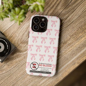 May include: A white phone case with a pink bow pattern. The case has a red circle with a white line through it and the text "No Blood Transfusion NO BLOOD Durable Power of Attorney for Health Care Jehovah's Witness See Medical Directive in Wallet/Purse".