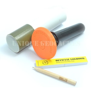 May include: Geocaching kit with an orange stamp, black handle, and a cylindrical container. Includes a yellow logbook and a pencil. The stamp has the text "geocaching point". The container has the text "UNIQUE GEOCACHERS".