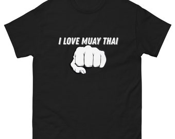 May include: Black t-shirt with white text that reads "I Love Muay Thai" and a white fist graphic.