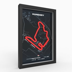 May include: A black framed print of the Hungaroring race track in red on a black background. The print includes the text "HUNGARY", "LOCATION: Mogyoród, HUNGARY", "TURNS: 16", "OPENED: 1986", and "LENGTH: 4.381 km".