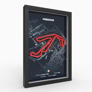 May include: Framed print of the Misano race track in Italy. The track layout is highlighted in red against a dark background. The print includes the track name, location, number of turns, opening year, and length of 4.226 meters.