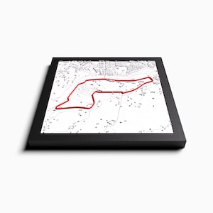 Puede incluir: Un mapa 3D enmarcado de un circuito de carreras con una línea de pista roja. El mapa está rodeado por un marco negro.