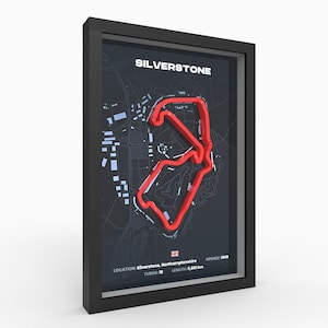May include: A framed print of the Silverstone racetrack in England. The track is outlined in red on a black and white map. The print includes the track's name, location, length, number of turns, and year opened.