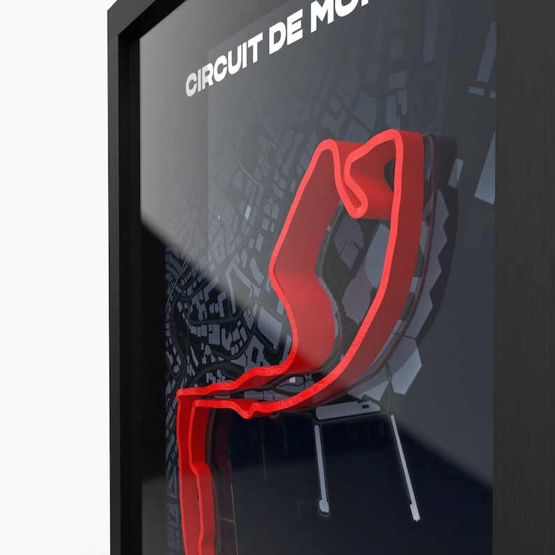 May include: A framed black and white map of a city with a red race track highlighted. The text "CIRCUIT DE MONACO" is at the top of the map.