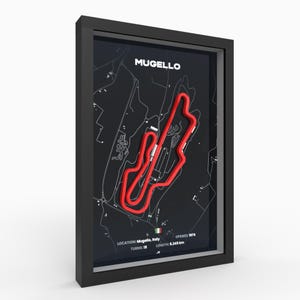 Può includere: Opera d'arte incorniciata con il circuito del Mugello in Italia. Il tracciato della pista è rosso su sfondo nero, all'interno di una cornice nera. Il testo include "MUGELLO", "LOCATION: Mugello, Italy", "TURNS: 15", "OPENED: 1974" e "LENGTH: 5.245 km".