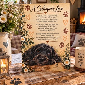 May include: A rectangular wooden sign featuring a black Cockapoo dog illustration, white daisy floral borders, and brown paw print and heart motifs. The text reads A Cockapoo's Love followed by a poem about the dog breed, with small branding text at the bottom.