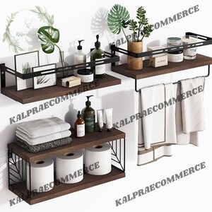 May include: Three wooden shelves with black metal frames, mounted on a white wall. The top shelf has a potted plant, a jar of bath salts, and a bottle of liquid soap. The middle shelf has a bottle of liquid soap, a jar of bath salts, and a framed picture. The bottom shelf has two rolls of toilet paper, a bottle of liquid soap, and a stack of towels. The shelves are decorated with a leafy plant.