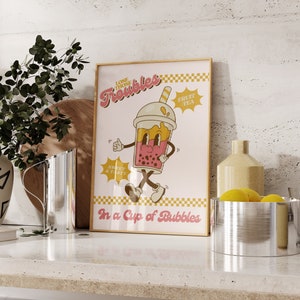 May include: A pink and yellow poster with a cartoon illustration of a bubble tea cup with a face and legs. The poster says "Lose Those Troubles In a Cup of Bubbles" and "Fruit Tea".