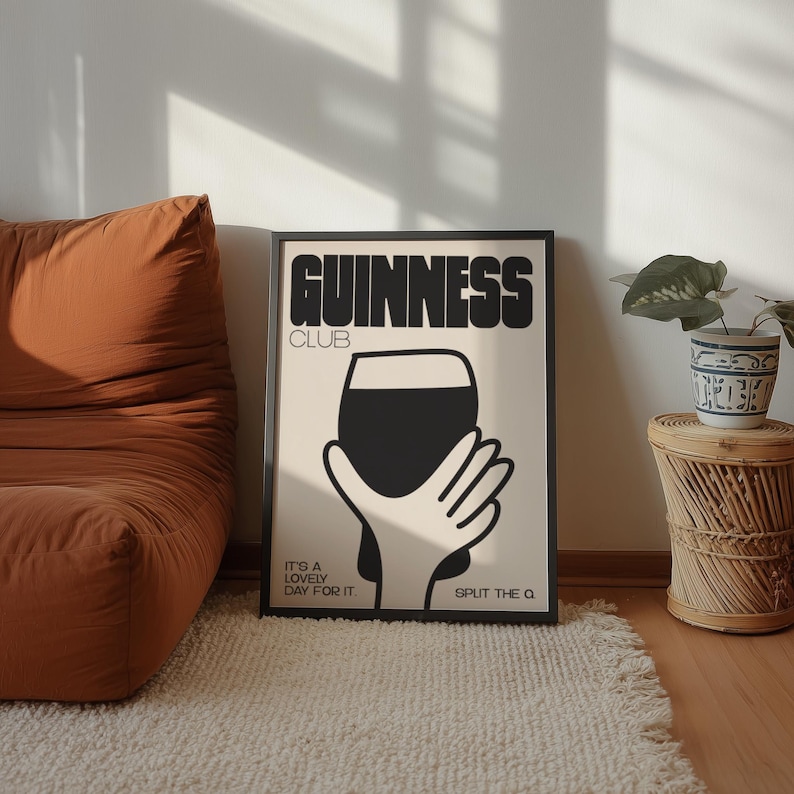 Pu&ograve; includere: Poster con cornice nera con la scritta "GUINNESS CLUB" in nero. Il poster presenta una grafica nera di una mano che tiene una pinta di Guinness. &Egrave; incluso anche il testo "IT'S A LOVELY DAY FOR IT. SPLIT THE Q".