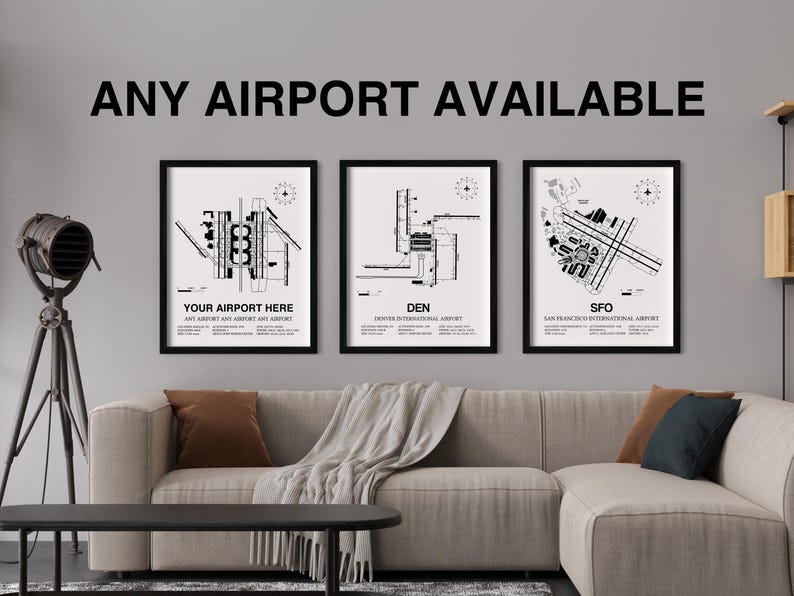 May include: Three black and white framed prints of airport layouts. The prints are hanging on a gray wall above a light gray couch. The prints feature the text "Your Airport Here", "DEN", and "SFO".