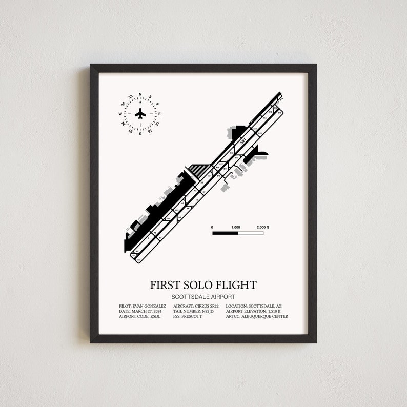 May include: Black and white minimalist airport diagram print.  Features a compass rose, scale, and runway details for Scottsdale Airport (KSDL). Text includes pilot, date, aircraft, tail number, location, and elevation.  Perfect for aviation enthusiasts or as a first solo flight keepsake. The print is framed in black.