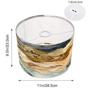 May include: A cylindrical lampshade with a watercolor-style design in shades of brown, beige, and blue. The lampshade is 9.0 inches (23.0 cm) high and 11 inches (28.0 cm) in diameter. The top opening is 1.6 inches (4.2 cm) wide. The lampshade is designed to fit a standard lamp base.