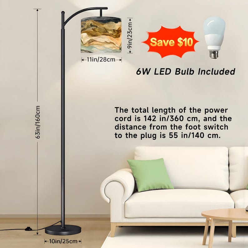 May include: A black floor lamp with a lampshade featuring a beige and brown abstract design. The lamp is 63 inches (160 cm) tall, with a 10-inch (25 cm) base and a lampshade that is 11 inches (28 cm) wide and 9 inches (23 cm) tall. Includes a 6W LED bulb.