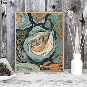May include: A framed art print featuring an oyster illustration in shades of blue, tan, and orange. The artwork depicts an open oyster shell, seaweed, and a crab against a dark blue background. The print is displayed on a white surface.