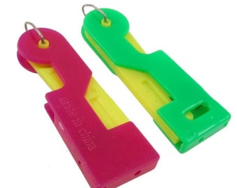 May include: Two plastic needle threaders, one pink and one green, with yellow accents. Both threaders have a loop at the top and the text "Made in China" is printed on the pink threader.