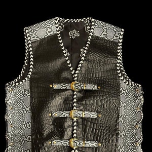 May include: Black leather vest with a white and black snake skin pattern on the sides. The vest has a zipper closure, four buckles, and a braided trim.