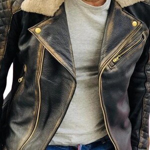 May include: A black leather jacket with a brown faux fur collar and gold zipper accents. The jacket has a distressed look and is made of a soft, supple leather.