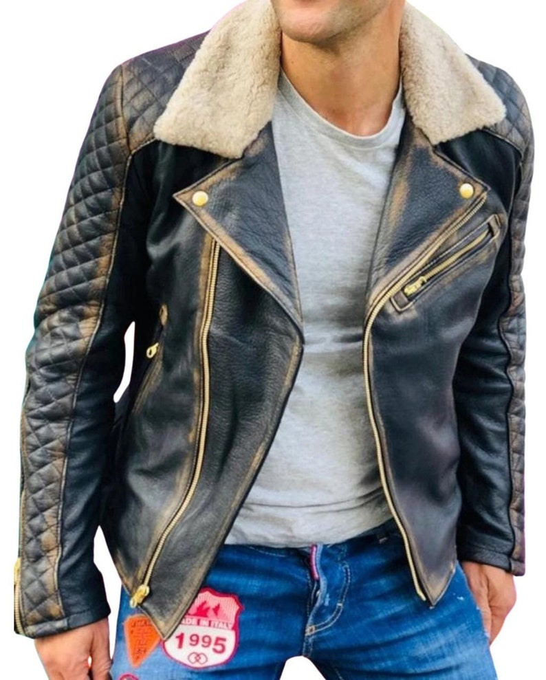 May include: A black leather jacket with a quilted design on the sleeves and a brown faux fur collar. The jacket has a zipper closure and gold-toned hardware. The jacket is distressed and has a vintage look.
