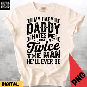 Könnte beinhalten: Cremefarbenes T-Shirt mit dem schwarzen Text: "MY BABY DADDY HATES ME 'CAUSE I'M Twice THE MAN HE'LL EVER BE". Das Shirt hat einen Rundhalsausschnitt und kurze Ärmel. Das Wort "DIGITAL" steht unten links in Gelb.
