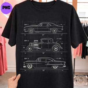 May include: Black t-shirt featuring a blueprint design of three classic cars. The design includes measurements in inches and the text "BAY 1", "BAY 2", and "BAY 3". The shirt has a crew neck and short sleeves.