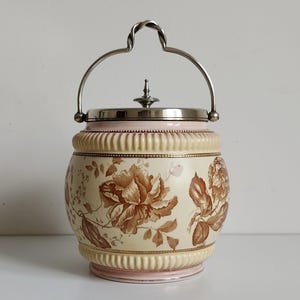 Barril de galletas de cerámica antiguo con tapa plateada y asa. Tarro de galletas con tapa y diseño floral. Fabricado en Inglaterra. Marcado.