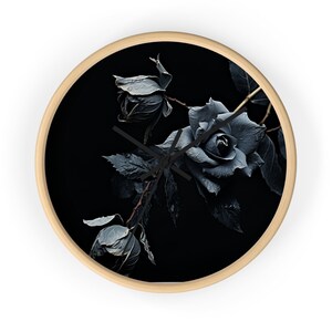 Può includere: Un orologio bianco e nero con una rosa blu scuro e boccioli su uno sfondo nero.