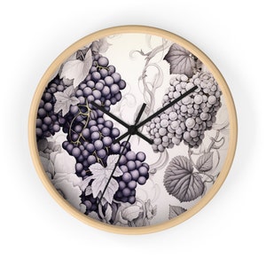 May include: Round wall clock with a light wood frame. The clock face features a detailed illustration of grapes and leaves in shades of purple and gray. Black clock hands indicate the time. A decorative piece for the kitchen or dining room.