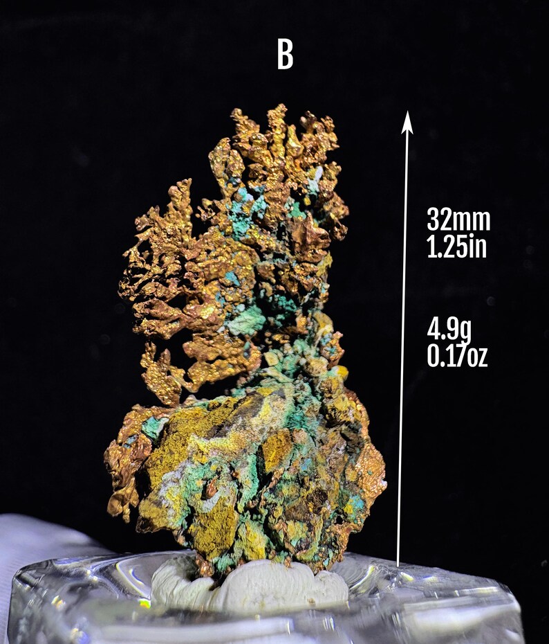 Puede incluir: Esp&eacute;cimen mineral de cobre natural con una superficie rugosa y texturizada. El mineral presenta tonos dorados, verdes y amarillos. El esp&eacute;cimen mide 32 mm de altura y pesa 4,9 g.
