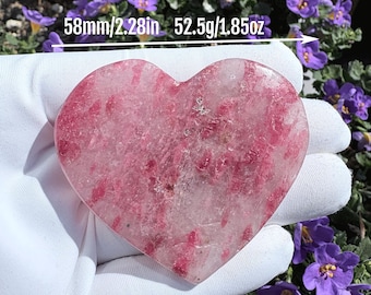 May include: A heart-shaped pink and white crystal stone labeled D, measuring 2.28 inches in width and weighing 1.85 ounces. The polished stone features a translucent base with vibrant pink inclusions throughout its smooth, flat surface.
