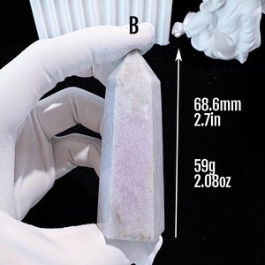 Puede incluir: Un obelisco de cristal morado claro, de 68,6 mm de altura y 59 g de peso. El cristal tiene forma hexagonal y una parte superior puntiaguda. El obelisco est&aacute; sostenido por una mano enguantada.