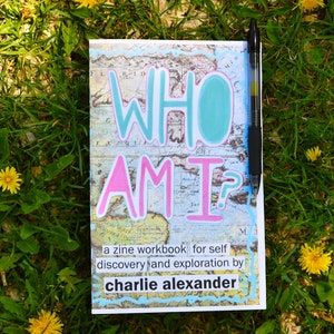 Könnte beinhalten: Ein Zine-Arbeitsbuch mit dem Titel "Who Am I?" mit einem Hintergrund aus einer Vintage-Karte. Das Arbeitsbuch dient der Selbstfindung und Erkundung durch Charlie Alexander.