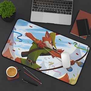 May include: A colourful cartoon mouse mat featuring Robin Hood, a fox dressed in green, holding a bow and arrow. The background is a blue sky with white clouds and colourful confetti.
