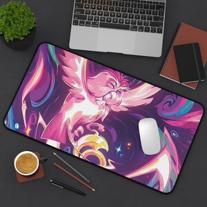 May include: A pink and purple galaxy-themed mousepad with a stylized illustration of a bird in flight. The mousepad has a black border and a smooth surface.