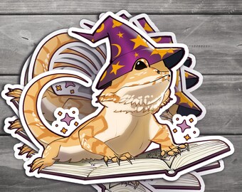 May include: A sticker featuring a cartoon bearded dragon wearing a purple wizard hat with gold stars. The lizard is reading a book with a magical theme, surrounded by sparkling stars. The sticker has a white border.
