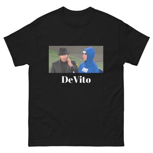 Puede incluir: Camiseta negra con una foto de dos hombres con sombreros. El texto "DeVito" está impreso en blanco debajo de la foto.