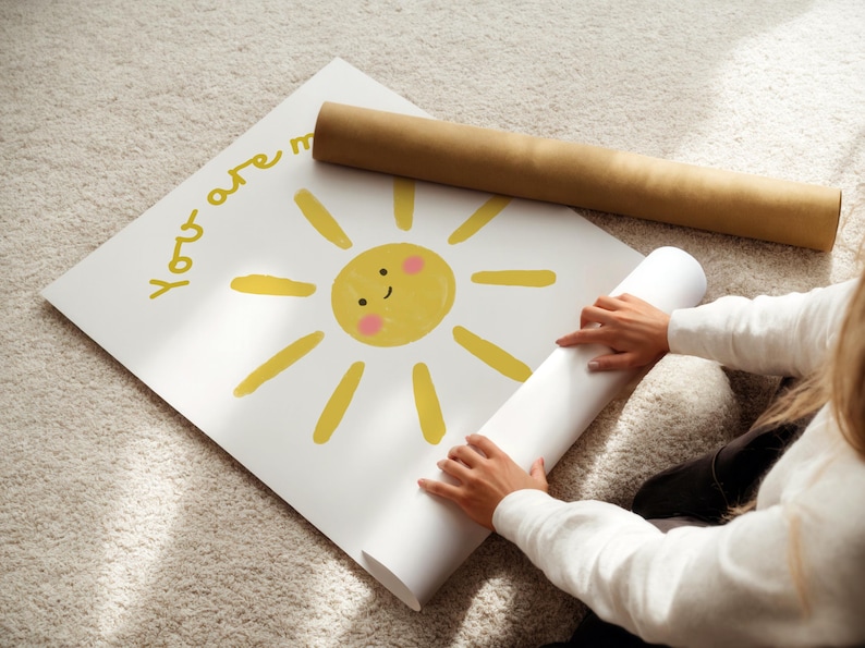 May include: A white poster with a yellow sun illustration and the words "You are my" in yellow. A rolled-up poster and a brown cardboard tube are also visible.