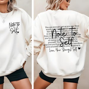 Może przedstawiać: Kremowa bluza z okrągłym dekoltem z czarnym napisem z przodu o treści Note to Self z małym sercem. Z tyłu znajduje się dłuższy inspirujący akapit z czarnym tekstem, również zatytułowany Note to Self, kończący się słowami Love, Your Strongest Self.